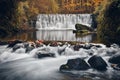 Mountain river with a cascade, cold water flows through the riverbed between wet rocks. Autumn mountain landscape