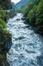 A mountain river flows between the woods of rocks.