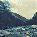 Mountain river with the forest and hills. Stone and rocks in riverbed. Cold fresh water current. Royalty Free Stock Photo