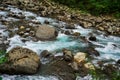 Mountain River rages on rocks on a cloudy day