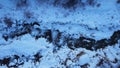 A mountain river runs along a snowy riverbed.