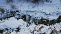 A mountain river runs along a snowy riverbed.