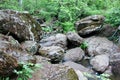 Mountain river - a small waterfall on a river with crystal clear water that flows among gray stones in a green forest on Royalty Free Stock Photo