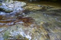 A mountain river stream flows down between huge cobble stones. Royalty Free Stock Photo