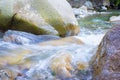 A mountain river stream flows down between huge cobblestones, shot at a long exposure. Blurry water and spray Royalty Free Stock Photo