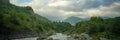 Mountain river stream landscape with dramatic cloudy sky at sunset Royalty Free Stock Photo