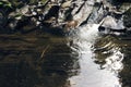 Mountain river surrounded by mountains. A waterfall flowing down from a Sheer cliffs . blue clear water of the river. Rocky stones Royalty Free Stock Photo