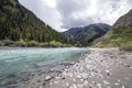 Mountain river with turquoise water with a bank of gray pebble sand and stones of various sizes Royalty Free Stock Photo