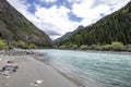 Mountain river with turquoise water with a bank of gray pebble sand and stones of various sizes Royalty Free Stock Photo