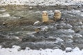 Mountain river with two old concrete piles