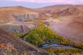 Mountain river in the valley with a view of yellow larches, mountains and autumn at dawn. Altai, Russia.