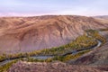 Mountain river in the valley with a view of yellow larches, mountains and autumn at dawn. Altai, Russia.