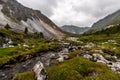 Mountain rivulet flows through large stones from the mountains.