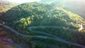 Mountain road aerial view. Asphalt in green forest