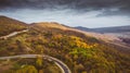 Mountain road and autumn trees in GUAM gorge `Guamka`, above North Caucasus, Russia. Yellow, red and green nature, high top view. Royalty Free Stock Photo