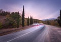 Mountain road with blurred cars in motion at sunset Royalty Free Stock Photo