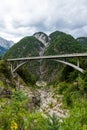 Mountain road with bridge spanning over a gorge in European Alps with mountain in background and cloudy skies Royalty Free Stock Photo