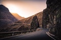 Mountain road on a cliff. Adventure roadtrip. Mountain pass with sunset through rocks. Winding road in the mountains. Early Royalty Free Stock Photo