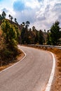 Beautiful curved roadway, rocks, stones, blue sky with clouds.