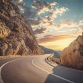 Mountain road at colorful sunset in summer. Beautiful curved roadway, rocks, stones, blue sky with clouds. Landscape Royalty Free Stock Photo