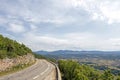 Mountain road curve above the forest and agricultural fields in French countryside Royalty Free Stock Photo