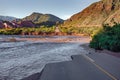 Mountain road cut by a rising river that eroded the land. Concept of immobilizing, blocking Royalty Free Stock Photo