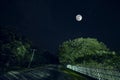 Mountain Road through the forest on a full moon night. Scenic night landscape of dark blue sky with moon. Azerbaijan. Long shutter Royalty Free Stock Photo