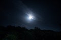 Mountain Road through the forest on a full moon night. Scenic night landscape of dark blue sky with moon Royalty Free Stock Photo