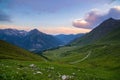 Mountain road leading to high mountain pass on the Italian Alps.. Expasive view at sunset, colorful dramatic sky, adventure road t
