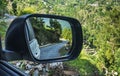 A mountain road reflected in a car mirror Royalty Free Stock Photo