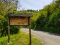 Mountain road sign, made out of wood next to road