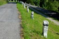 mountain road with traditional white stone bollards with a black stripe. Old stone pillars of granite stone perched on the lawn