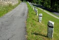 Mountain road with traditional white stone bollards with a black stripe. Old stone pillars of granite stone perched on the lawn by