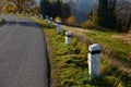 Mountain road with traditional white stone bollards with a black stripe. Old stone pillars of granite stone perched on the lawn by