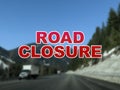 Blurred background of mountain roads with the words Road Closure in the foreground