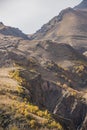 Mountain rocky slopes with yellow trees and cliffs