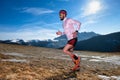 Mountain runner in action uphill on slippery ground