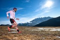 Mountain runner in downhill action on slippery ground