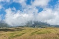 Mountain and savannah field with low cloud over hill. Rinjani mountain, Lombok island, Indonesia Royalty Free Stock Photo