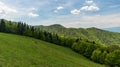 Horská scenéria s horskou lúkou a kopcami pokrytými lesmi vo Veľkej Fatre na Slovensku