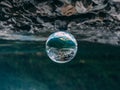 Mountain scenery reflection in a glass ball, lensball. klontalersee in the alps