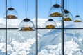 Mountain-shaped lamps hang inside a restaurant opposite a snow-capped mountains window in Austrian Alps.Selective focus on lamps