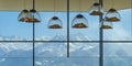 Mountain-shaped lamps hang inside a restaurant opposite a snow-capped mountains window in Austrian Alps.Selective focus on lamps