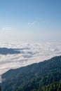 Mountain silhouette above the clouds at sunrise, view from the top view of mountains. Royalty Free Stock Photo