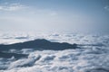 Mountain silhouette above the clouds at sunrise, view from the top view of mountains. Royalty Free Stock Photo