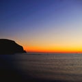 Mountain Silhouette at Sunrise: Brilliant Blue and Orange Colors on the Coast& x22; Royalty Free Stock Photo