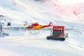 Mountain ski life rescue station with heavy machinery. Helicopter, snowcat and snowmobile standby ready to save tourist in