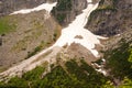 A mountain slope covered with eternal snow. Springtime view of greenery in a mountain lake on the Morskie Oko Royalty Free Stock Photo