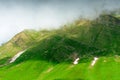 Mountain slope covered with grass with remnants of snow after winter, Caucasus Royalty Free Stock Photo