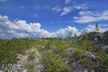 Mountain slope with large stones against a blue summer sky with white cumulus clouds Royalty Free Stock Photo